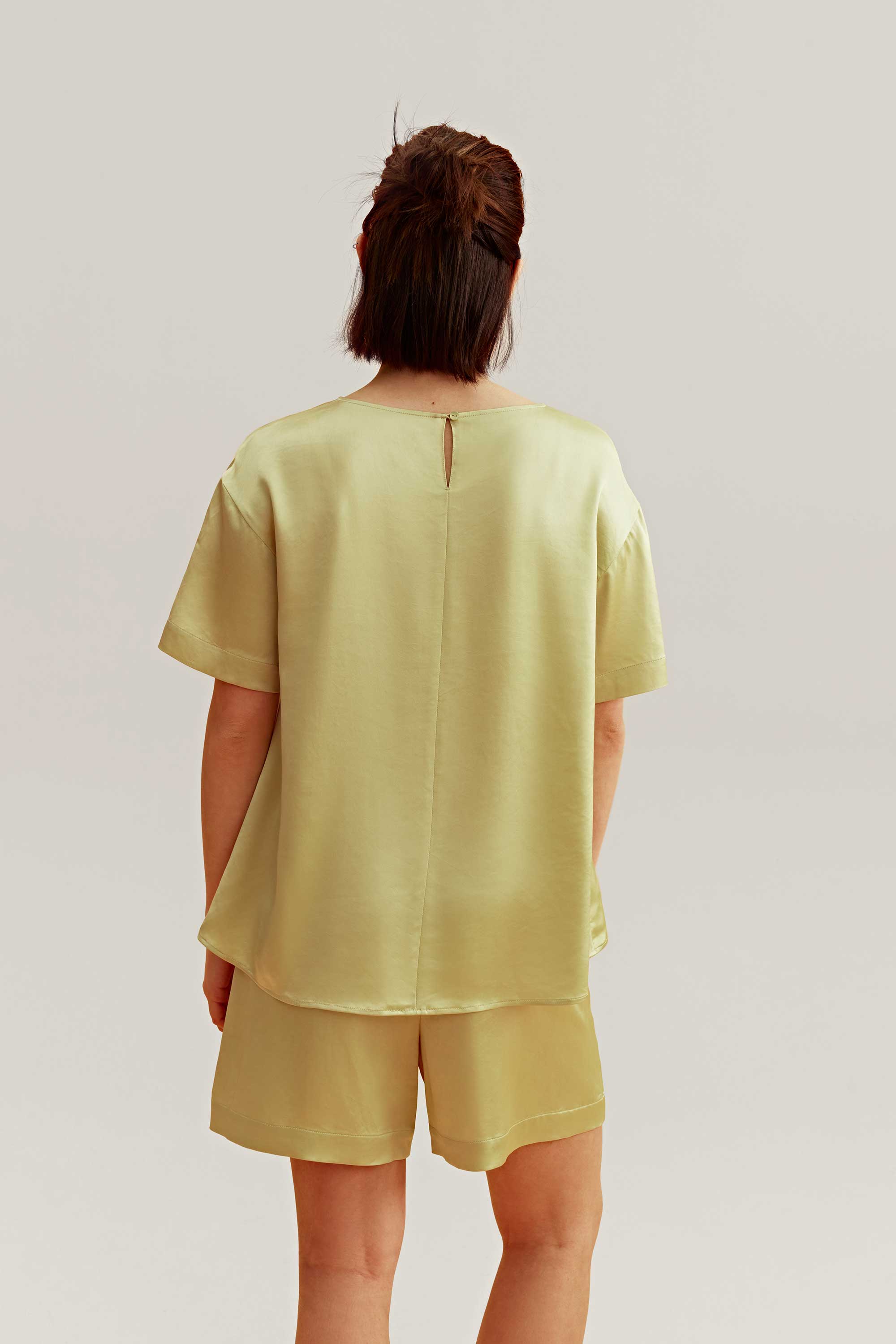 back of woman wearing a satin green short sleeve and shorts 