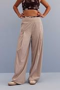 a woman wearing light beige wide-leg trousers and shoes