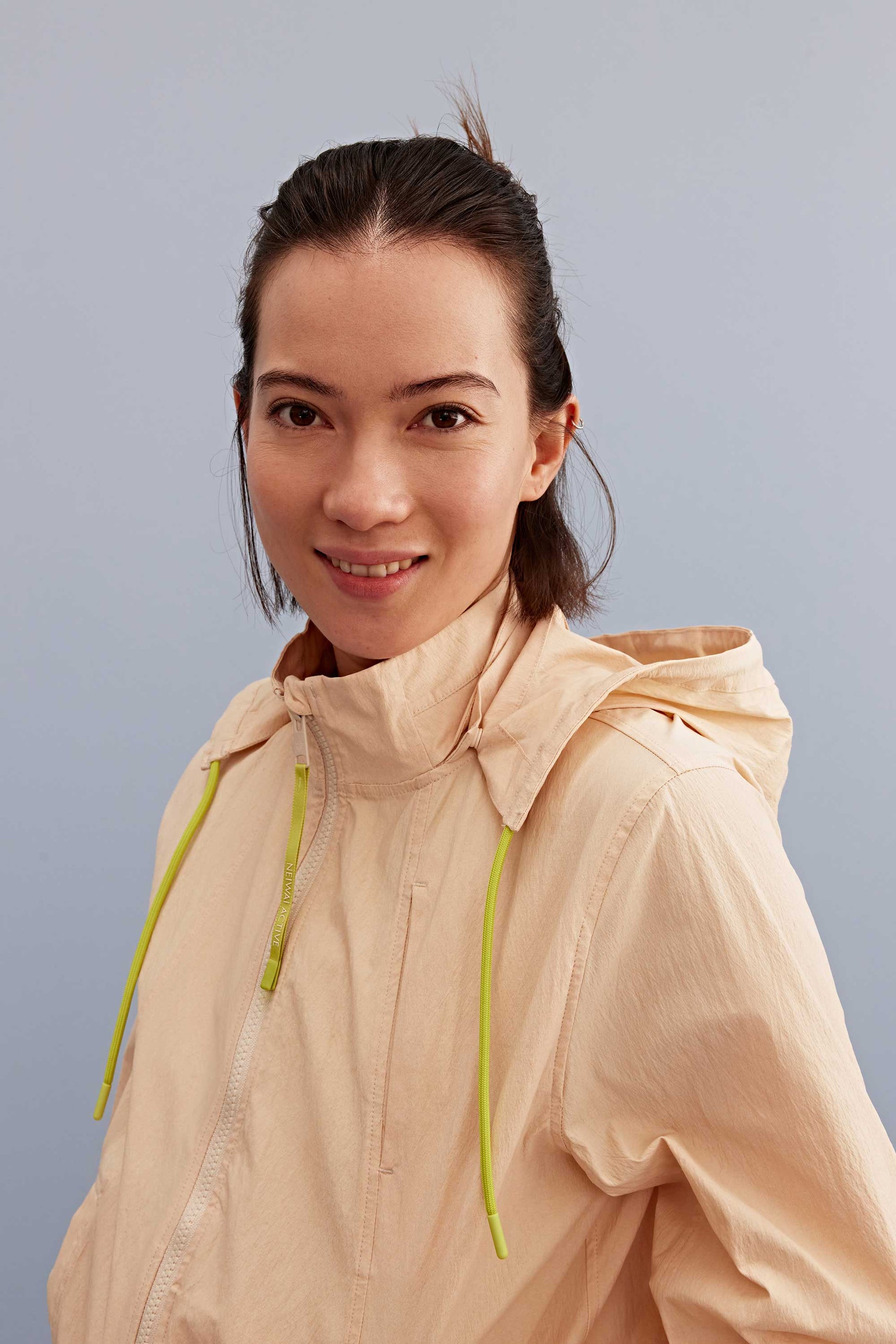 a woman smile wearing a warm yellow jacket