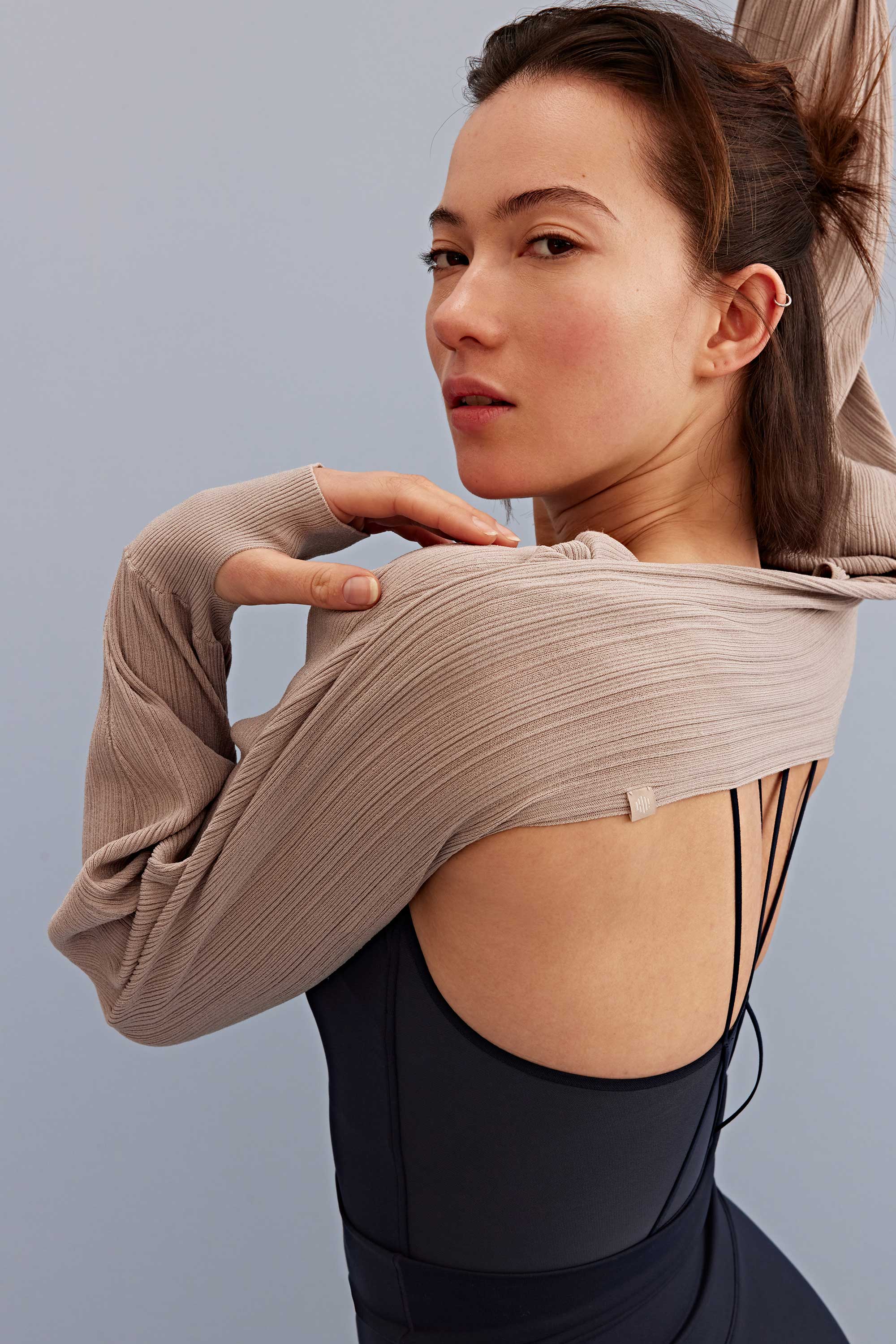 woman wearing a light brown shrug and black bra 