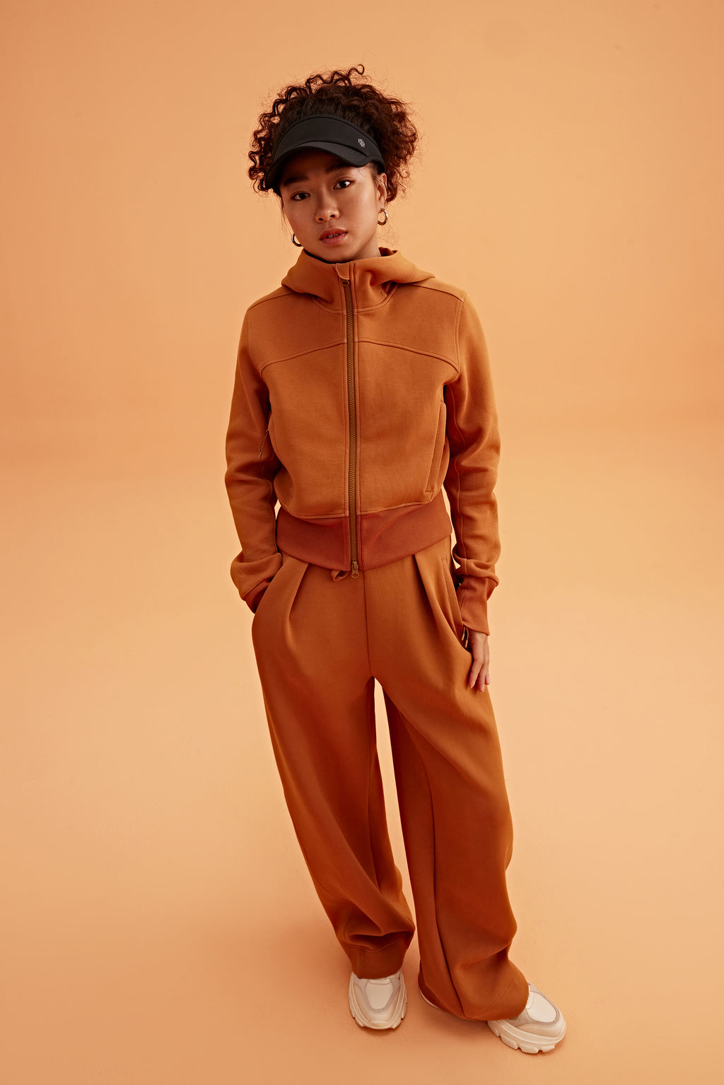 woman in caramel zip up hoodie and wide leg pants