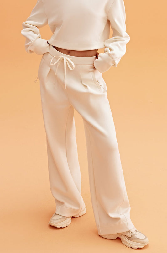 woman in white sweatshirt and wide leg pants