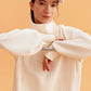 woman wearing a white visor and white half zip sweatshirt