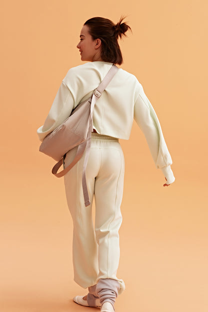 a woman with all white outfit pair a grey bag