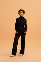 a woman wearing a light black hooded jacket and black pants