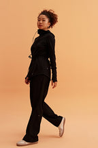 a woman wearing a light black hooded jacket and black pants