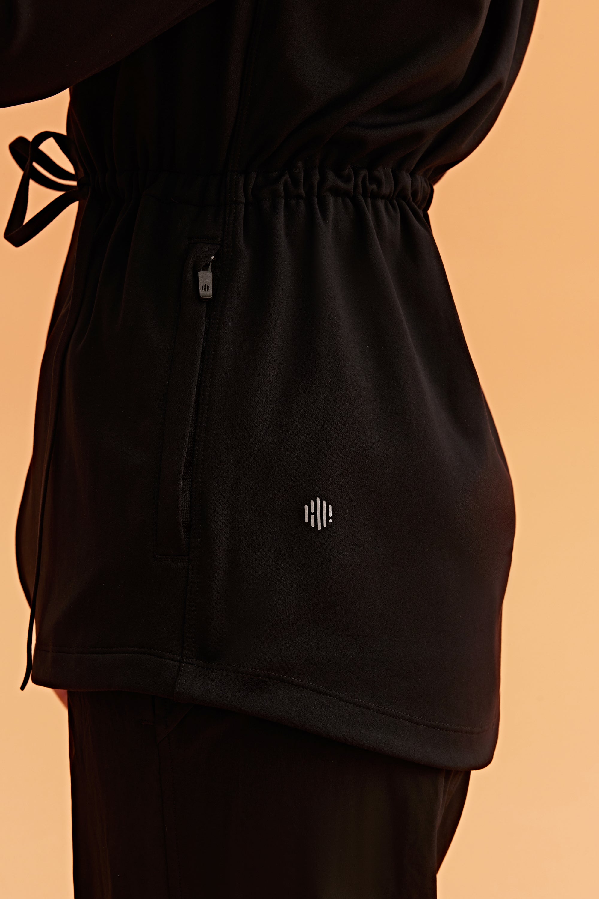 detail shot of the black hooded jacket shown neiwai active logo