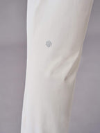 Close-up of off-white pants showcasing the subtle logo detail near the knee area.