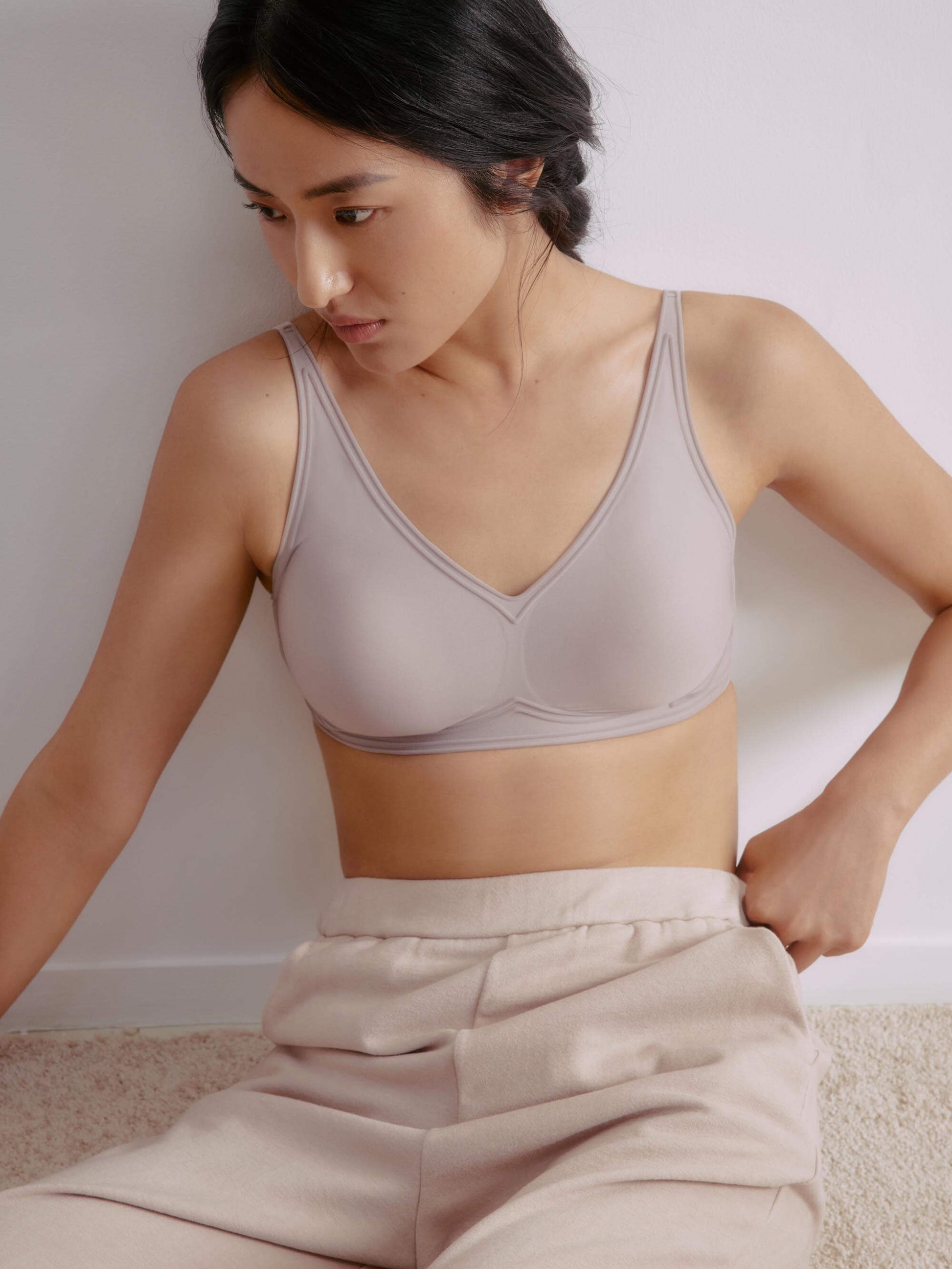 Woman wearing light gray bra with plunge neckline