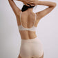 Back view of a model wearing a nude 3/4 cup bra and high-waisted seamless briefs, with the model’s arms raised, showcasing the bra’s adjustable straps.