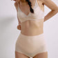 Front angled view of a model wearing a nude 3/4 cup bra and high-waisted seamless briefs.