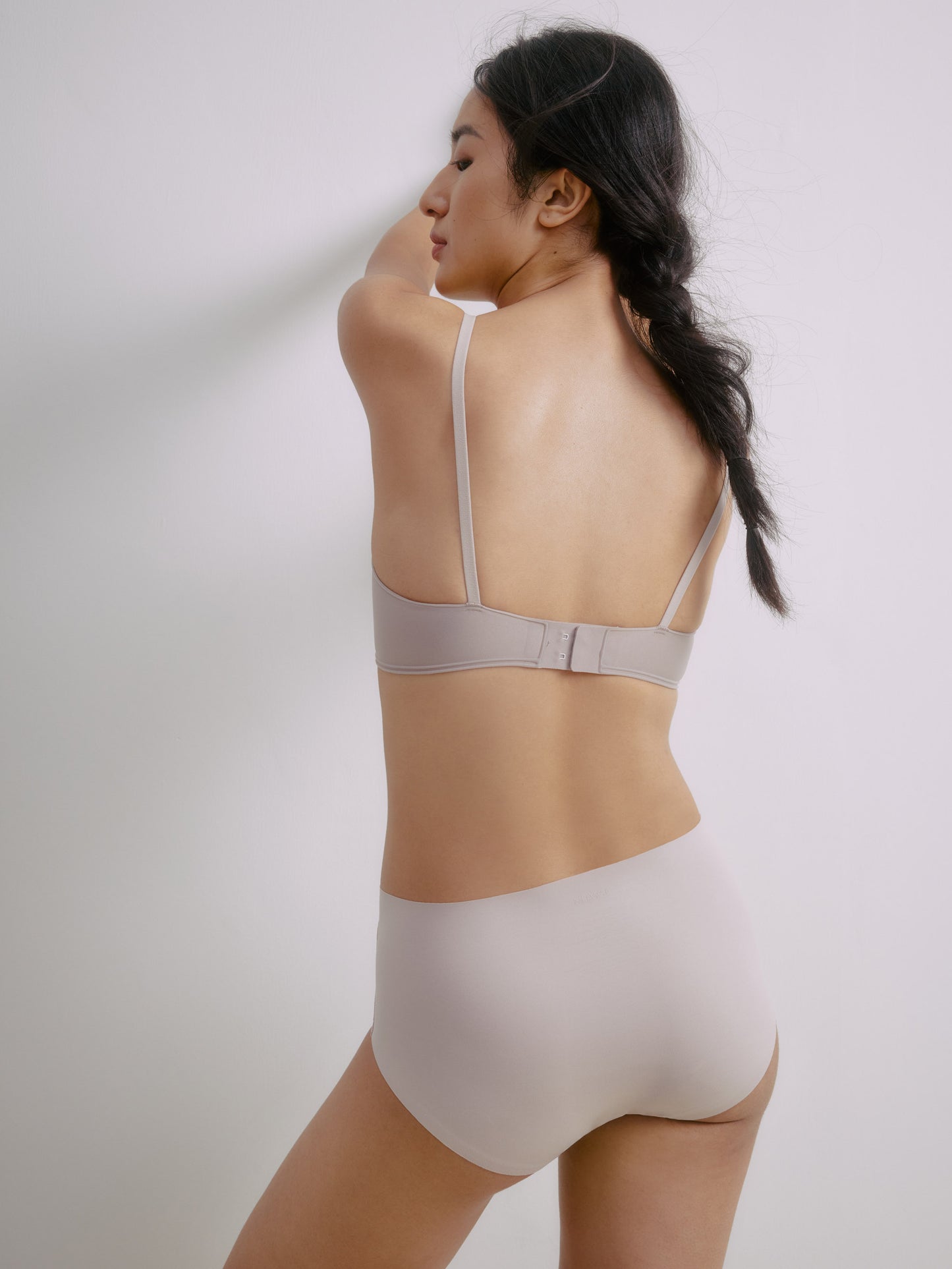 Back view of woman wearing light gray bra