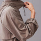 A side view of a model wearing a taupe zip-up sunblock jacket.