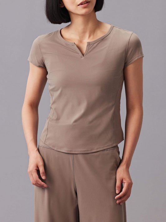 Woman wearing a taupe-colored short-sleeve top and matching pants.