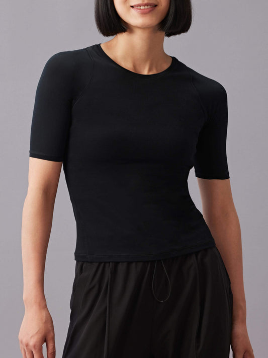 A woman wearing black short sleeve round neck T-shirt and black pants. 