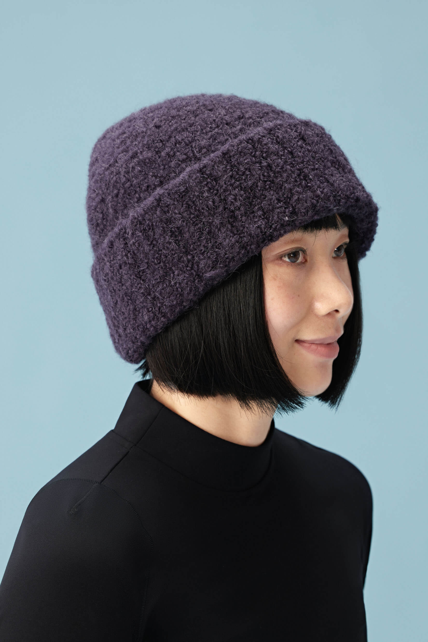 side view of woman wearing purple beanie