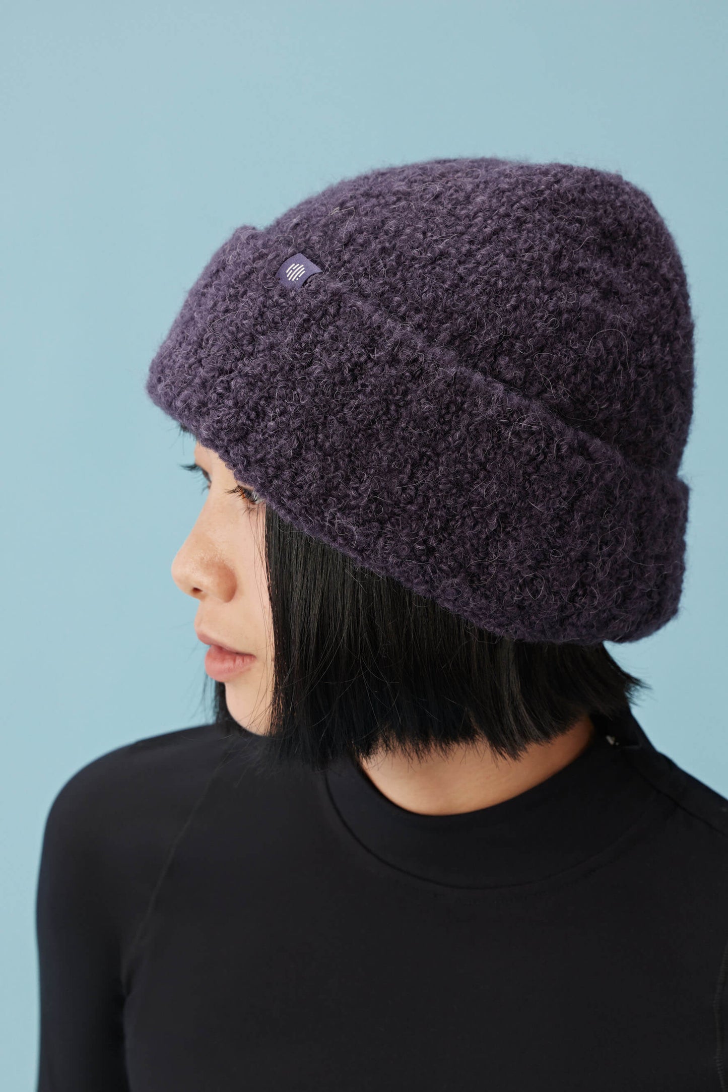 side view of woman wearing purple beanie