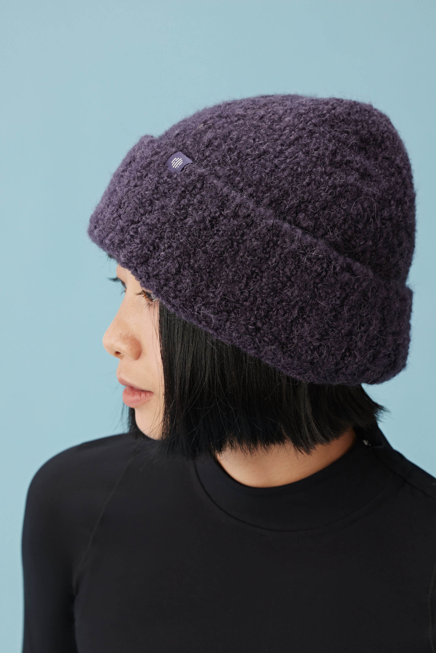 side view of woman wearing purple beanie