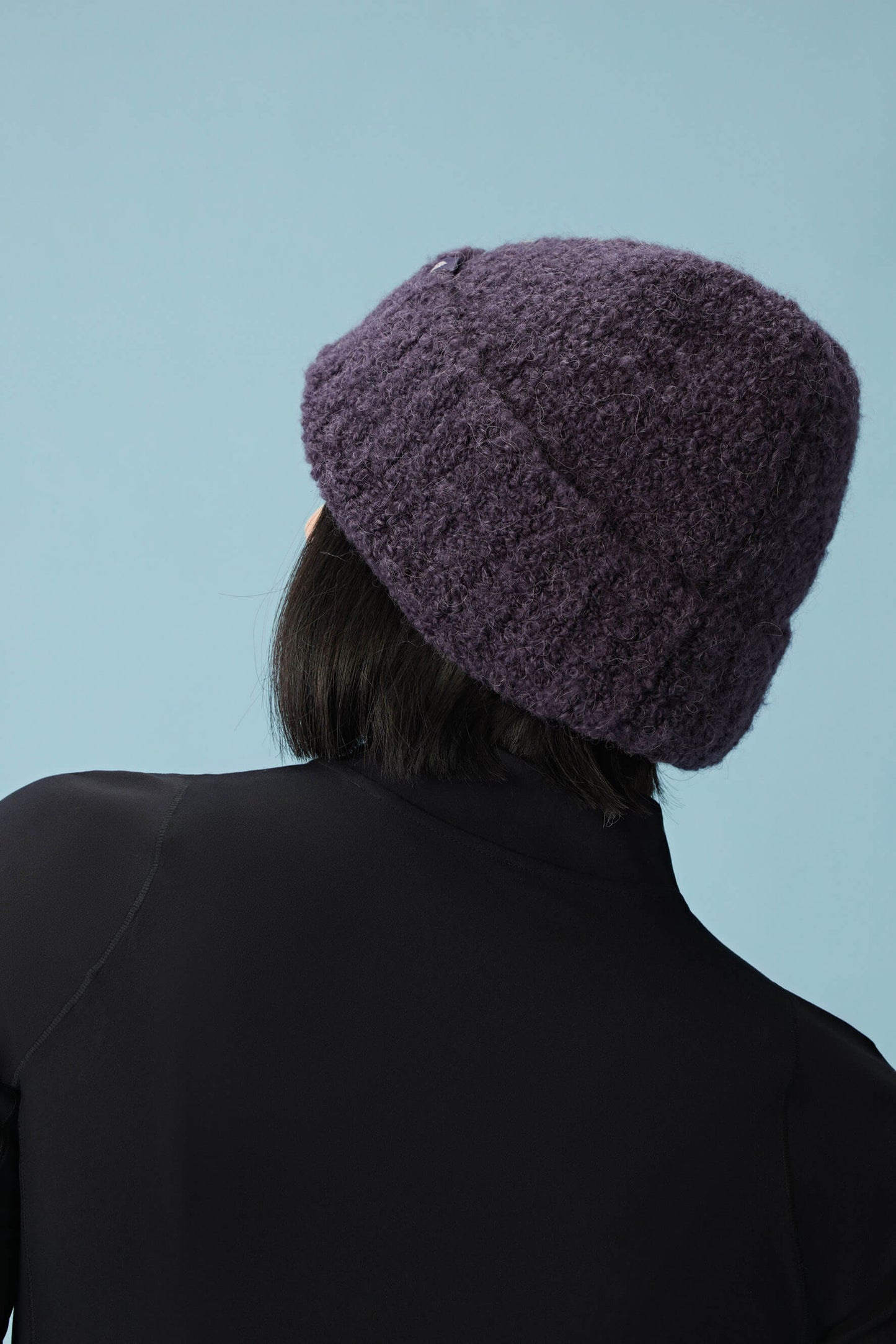 back of woman wearing purple beanie