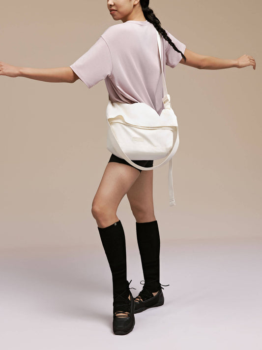 Model wearing white convertible cross body bag