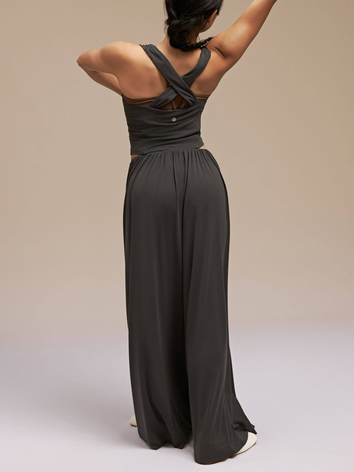 Back view of model wearing black wide leg pants and dance top