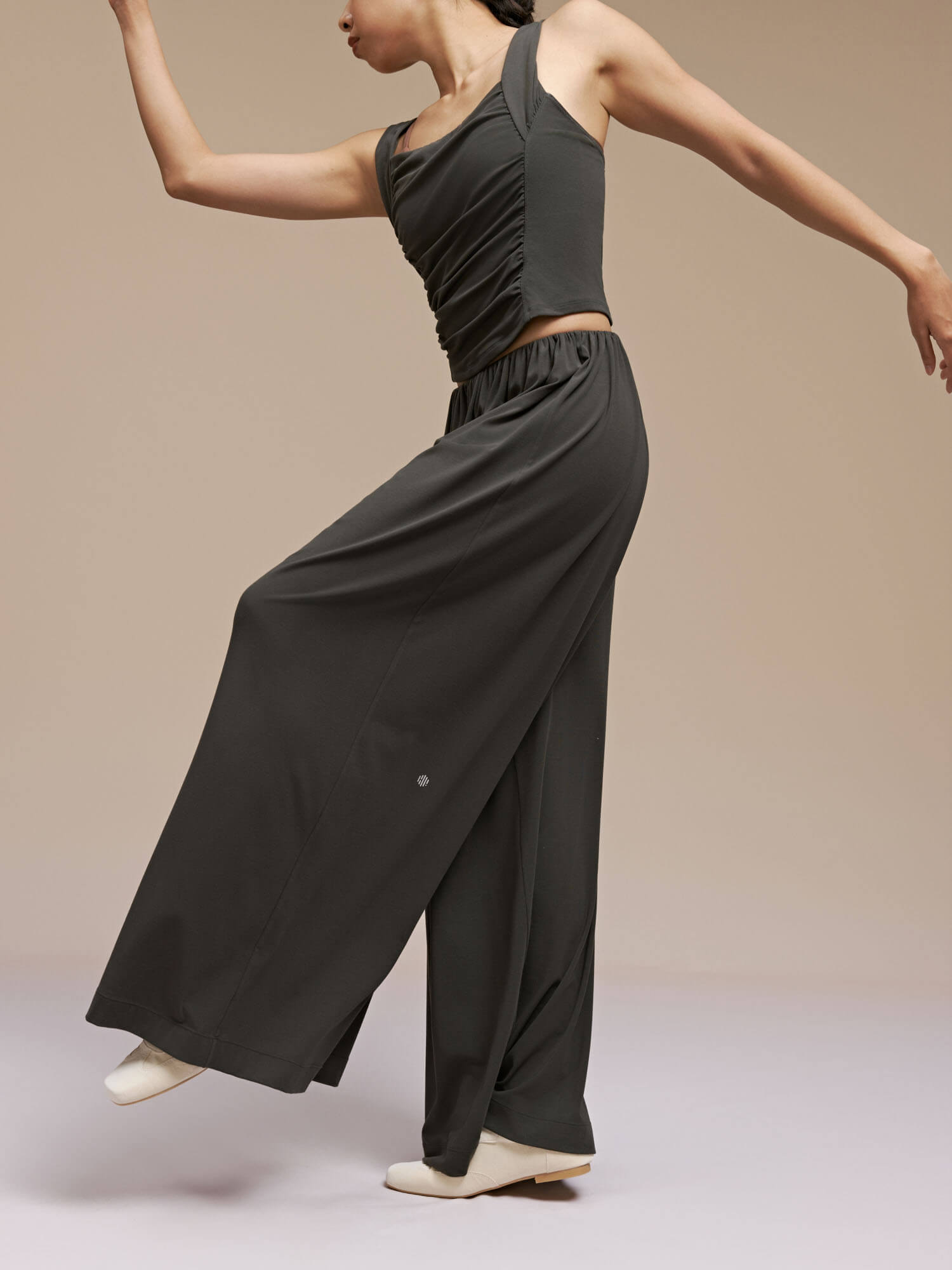 Side view of model wearing black wide leg pants and dance top