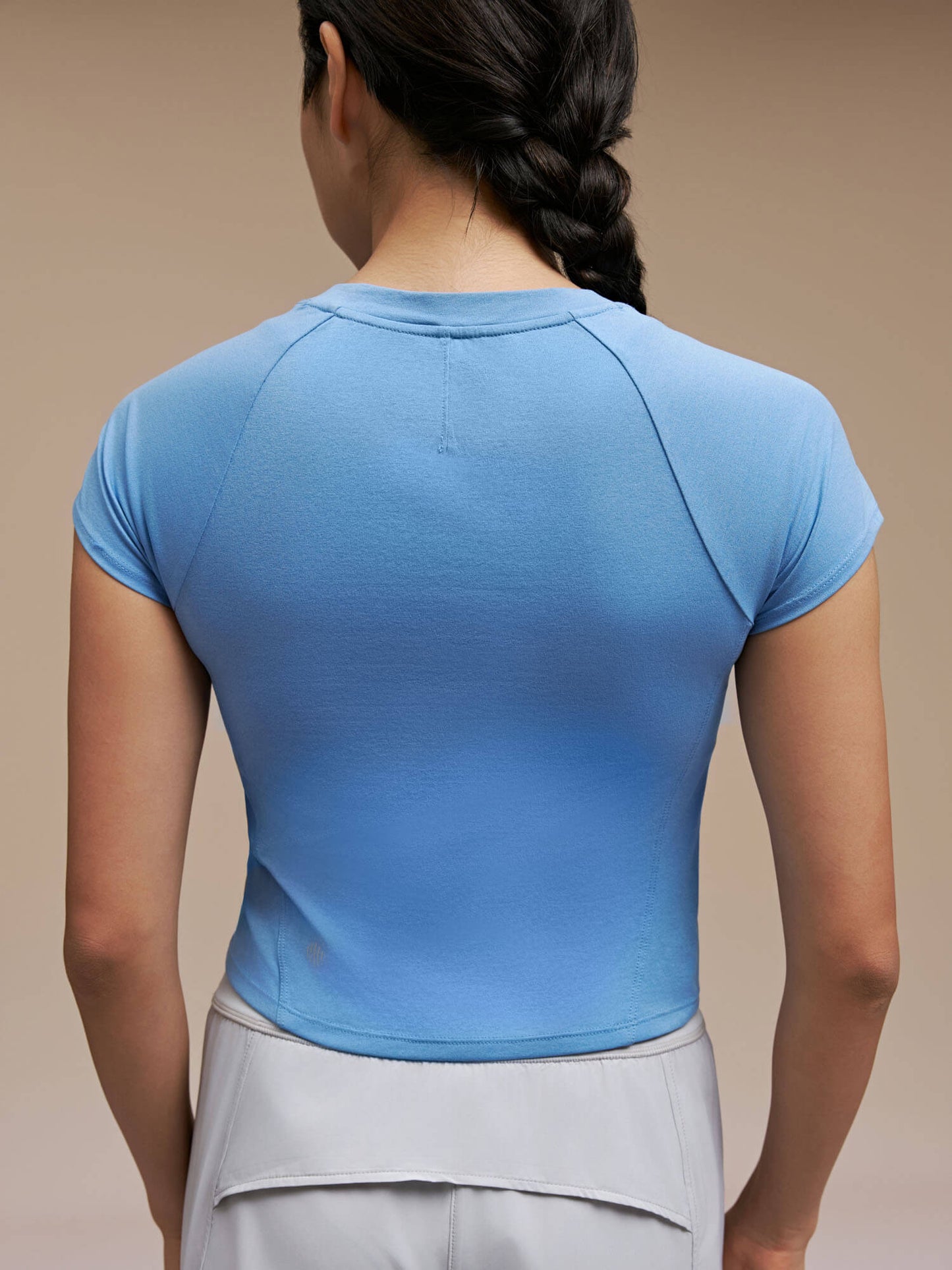 Back view of model wearing light blue dance tee 