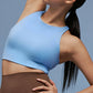 Model wearing light blue sports bra and brown leggings