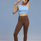 Model wearing light blue sports bra and brown leggings 