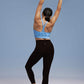 Back view of model wearing black leggings with arms raised