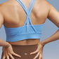 Back view of model wearing light blue sports bra and brown leggings