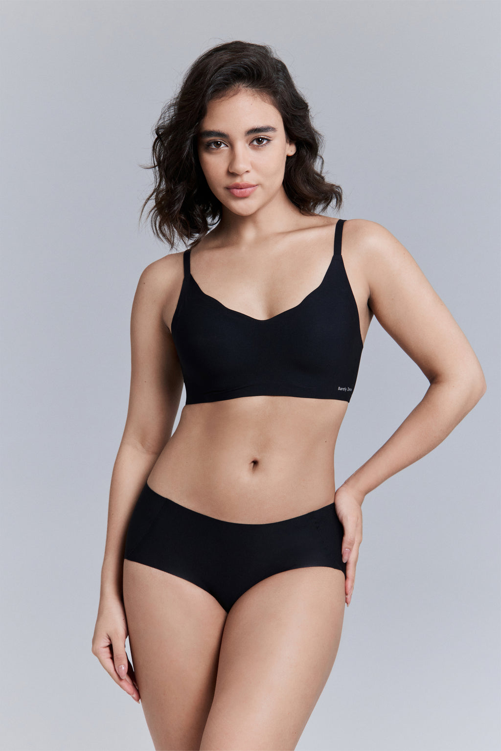 Model wearing a black bra and brief set.