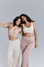 Two models posing together wearing matching athletic wear on a plain background