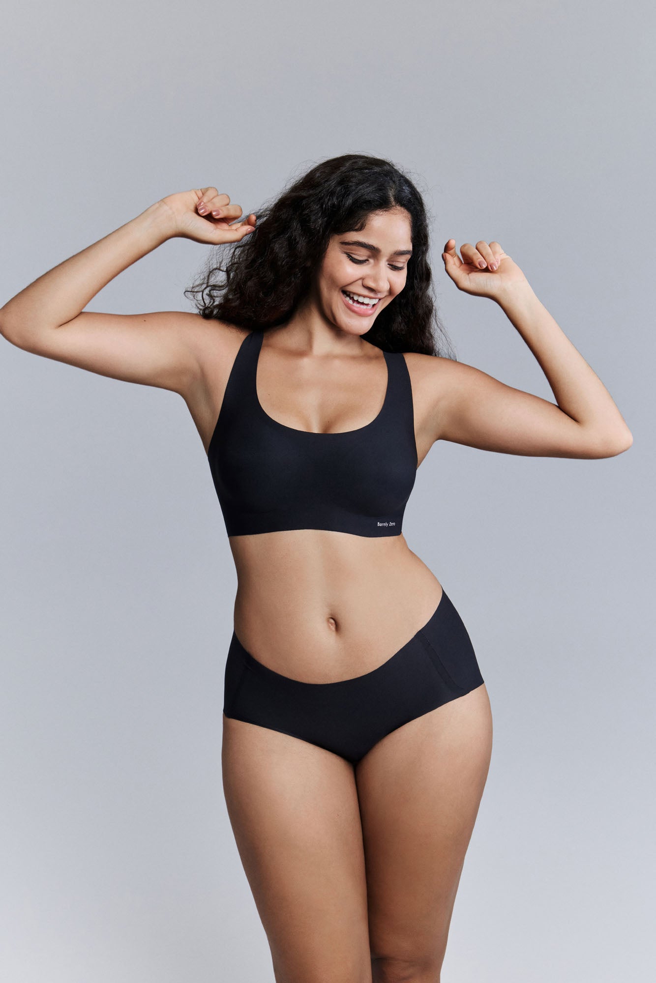 Model wearing black bra and brief set.