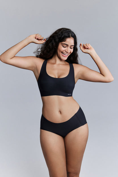 Model wearing black bra and brief set.