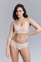 Model wearing a beige bra and panties set against a gray background