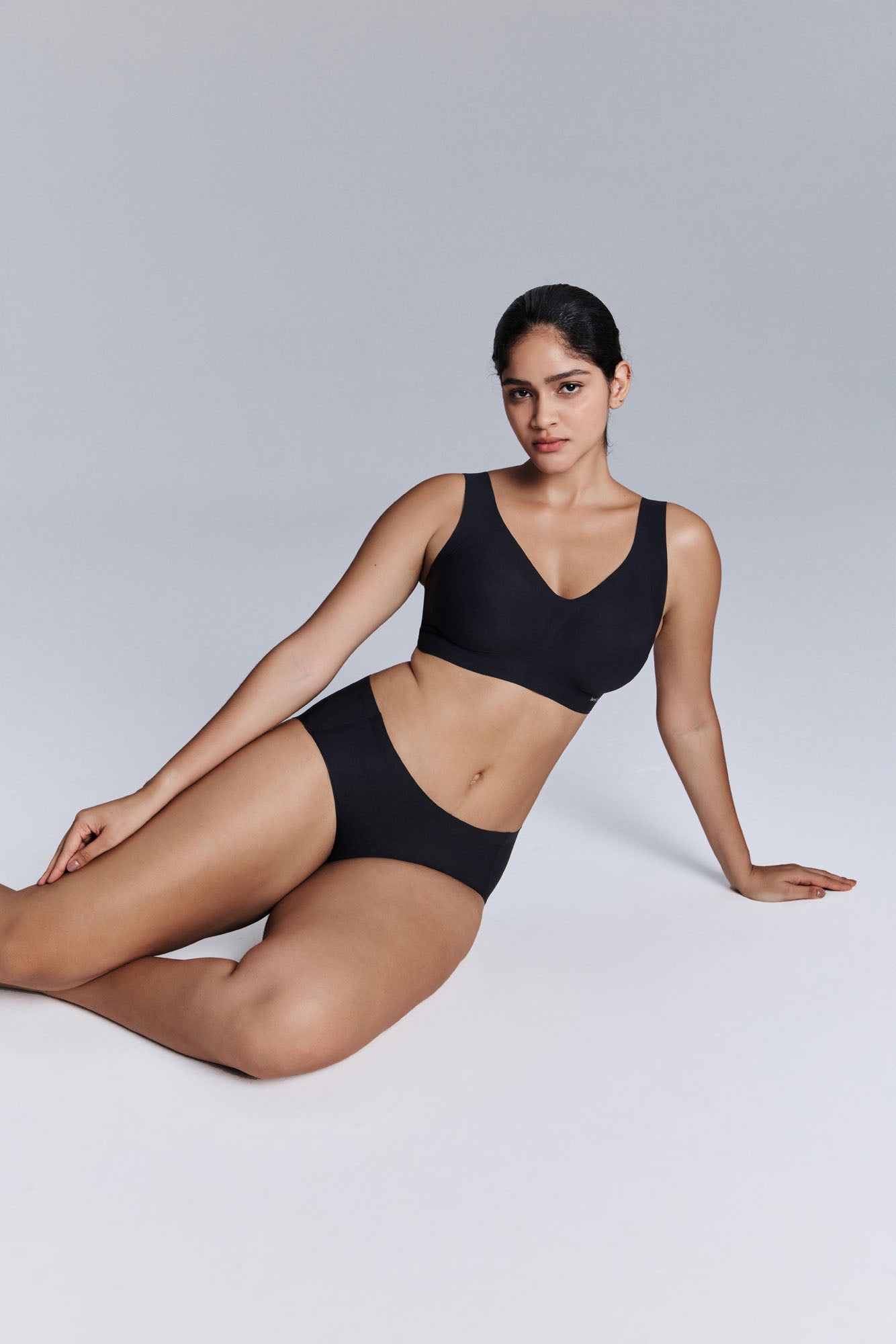 Model wearing black bra and brief set.
