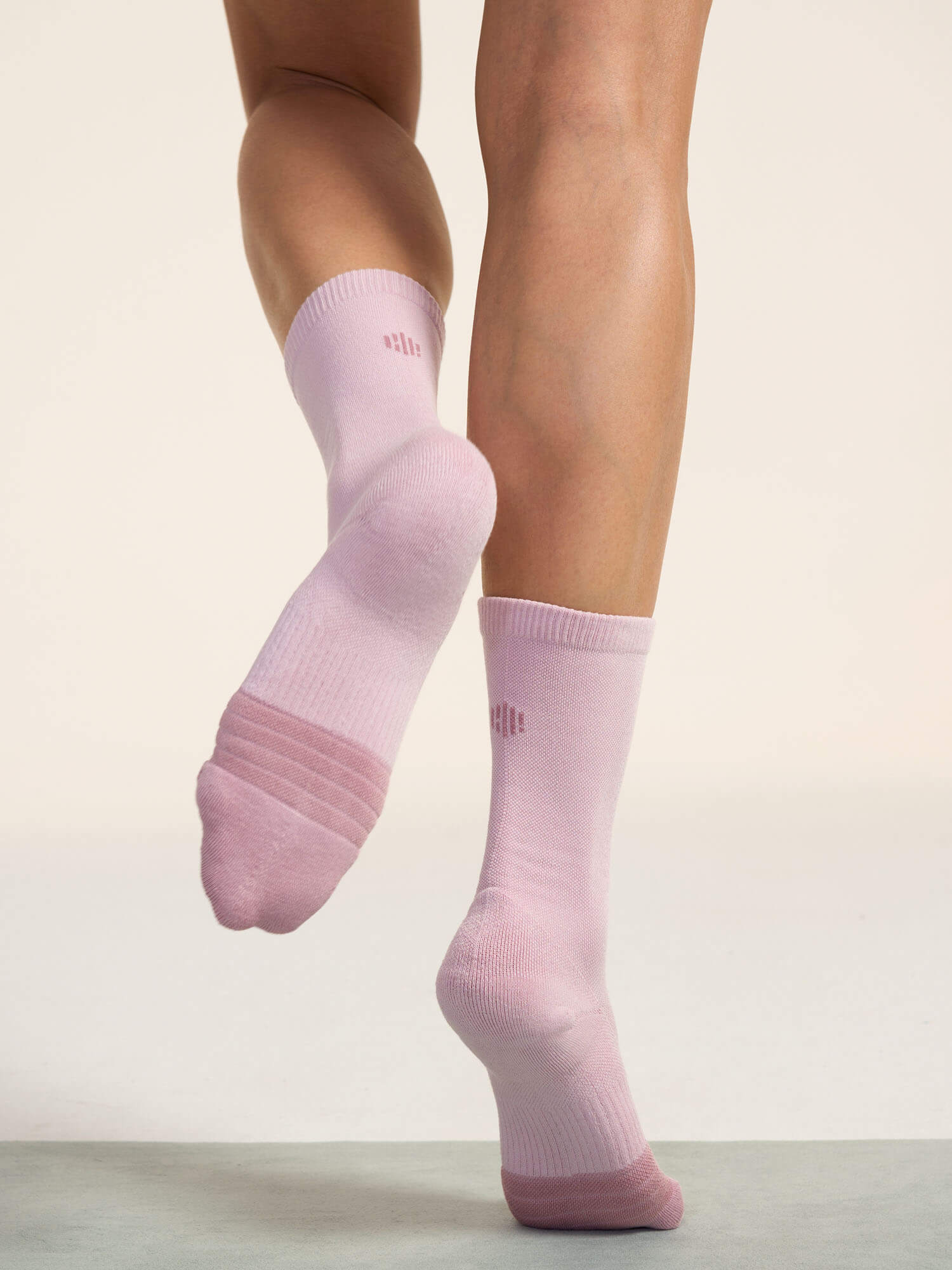 Model wearing light pink socks and showing bottom of socks