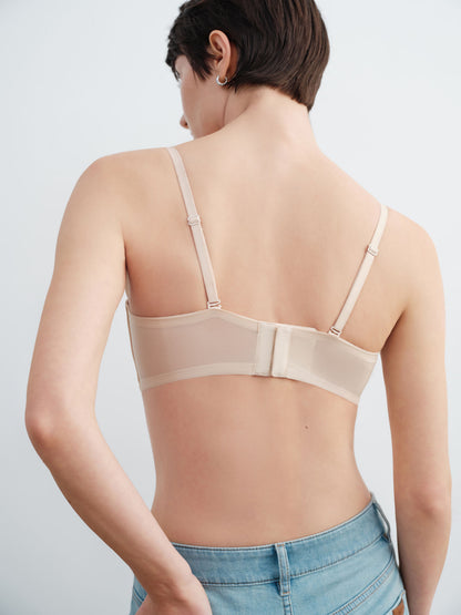 Beige bra worn by a model on a plain background.