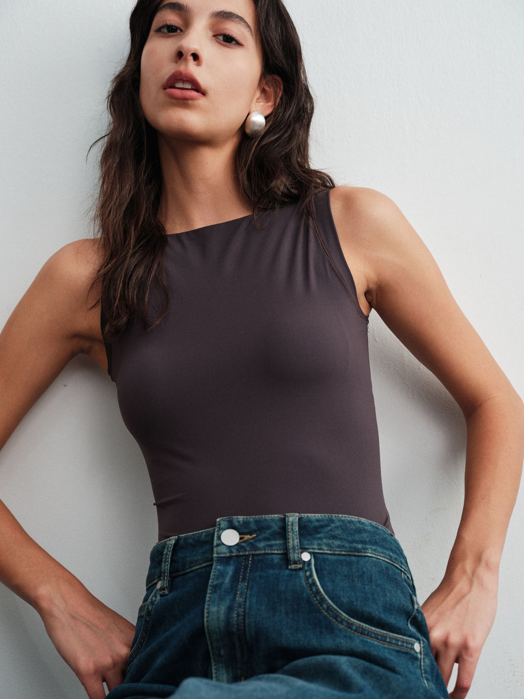 Model wearing black tank top and blue jeans.