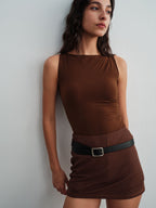 Model wearing a brown top with a skirt and belt against a plain background. Dark Earth color. 