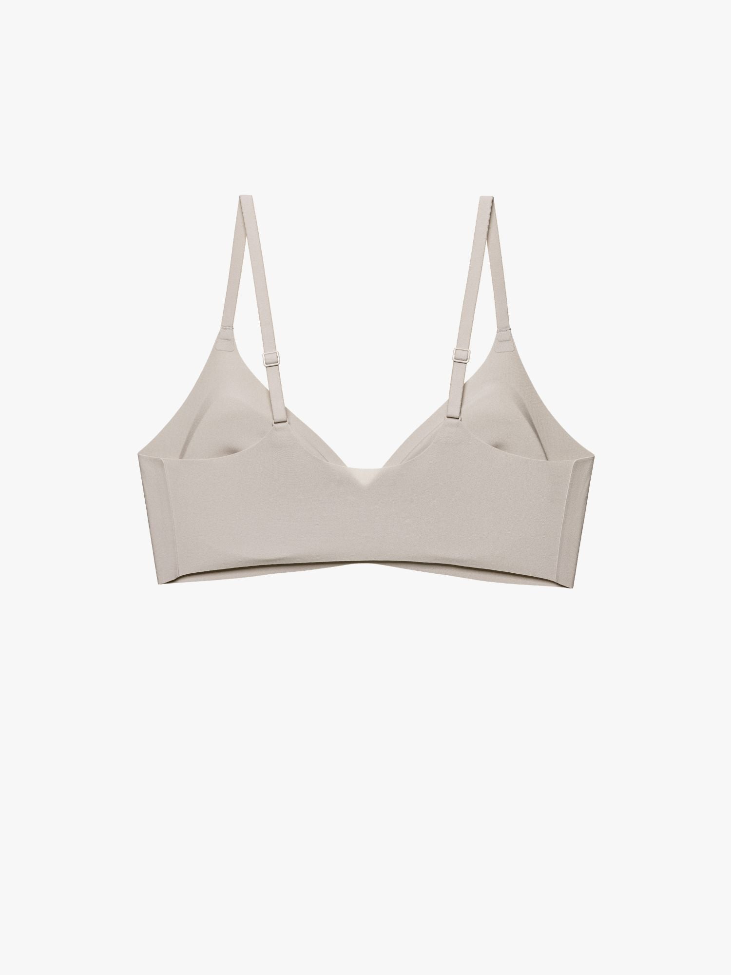 A light beige wireless bra with thin adjustable shoulder straps, displayed flat against a solid off-white background. Chateau Gray