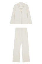 close up of cream color pajama button up top and pants
