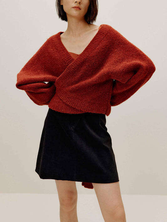 woman wearing a red wrap Cardigan and black skirt