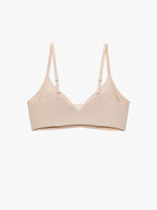A light beige wireless bra with thin adjustable shoulder straps, displayed against a clean white background. Treacly Almond