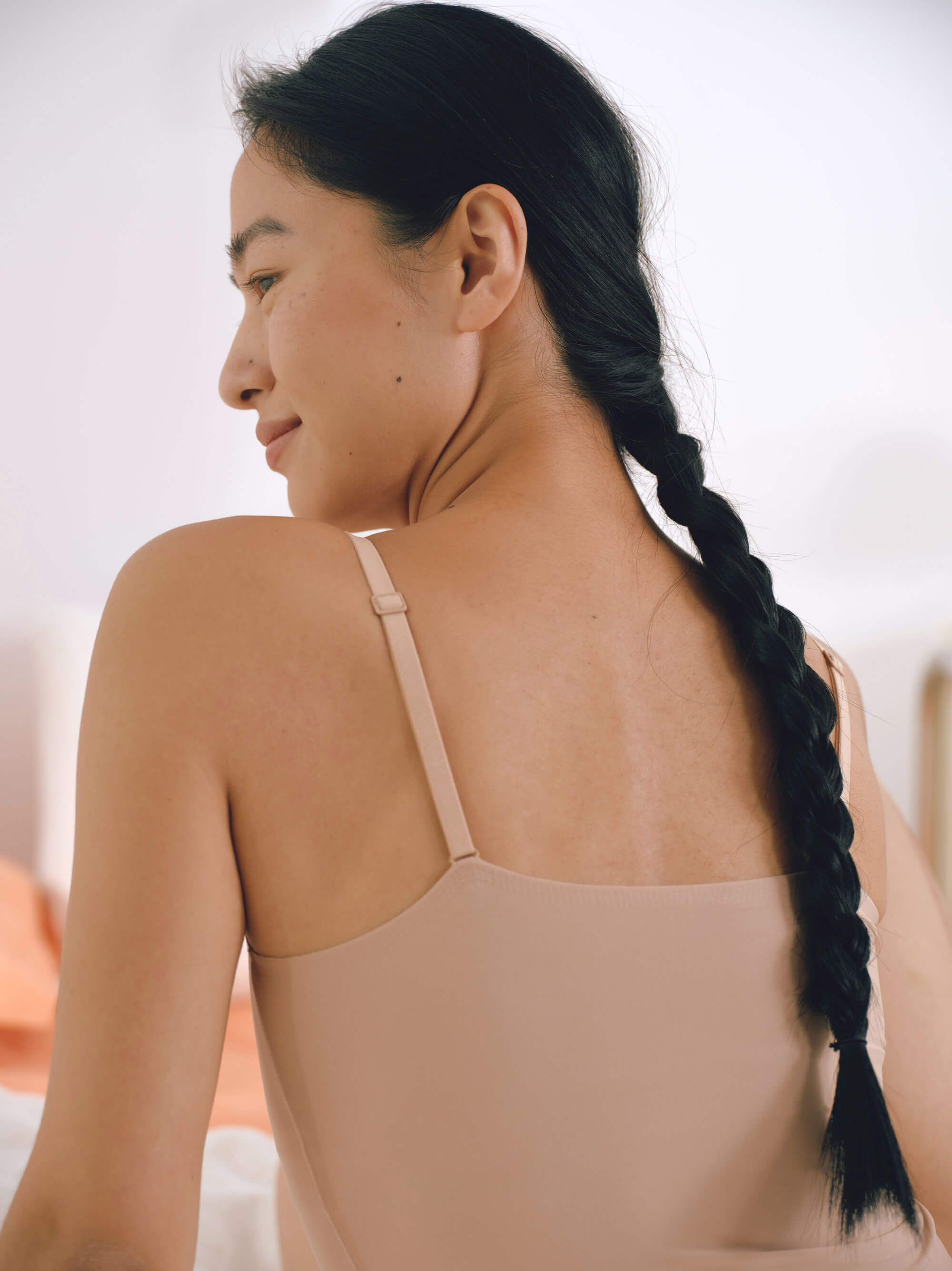 Back view of woman wearing beige camisole