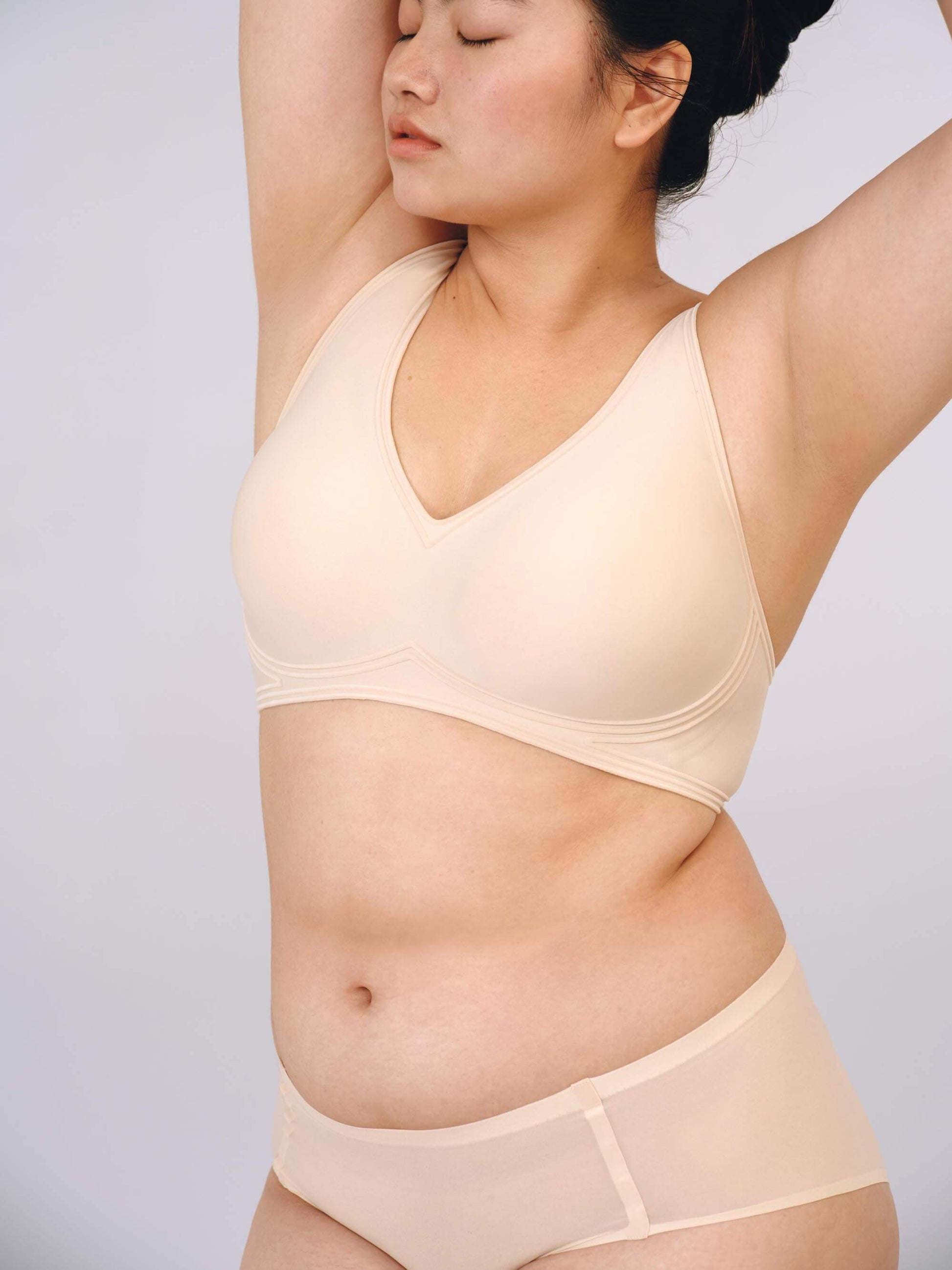 Woman wearing light beige bra with plunge neckline