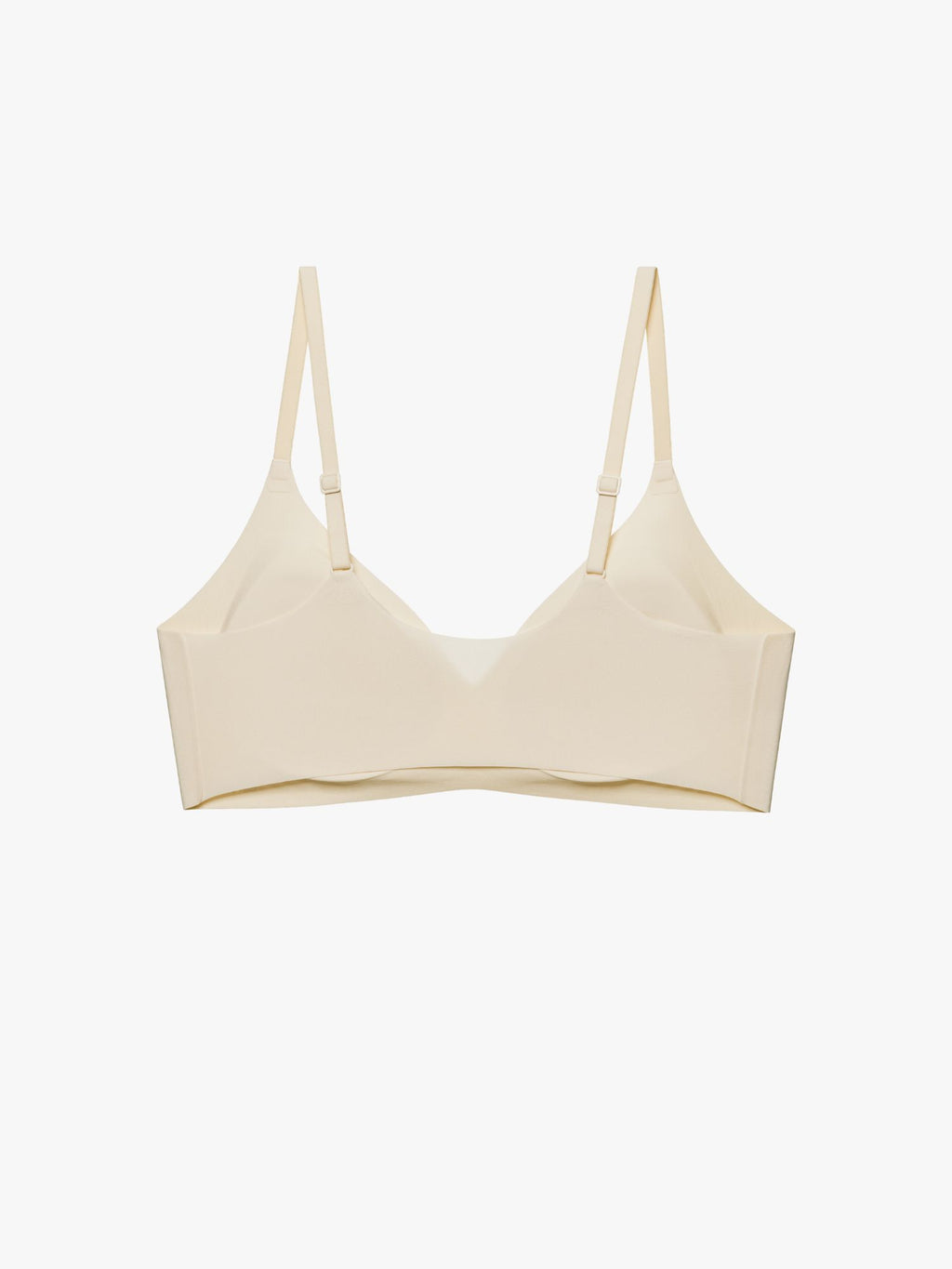 A light beige wireless bra with thin adjustable shoulder straps, displayed against a clean, solid off-white background. Eggwhite