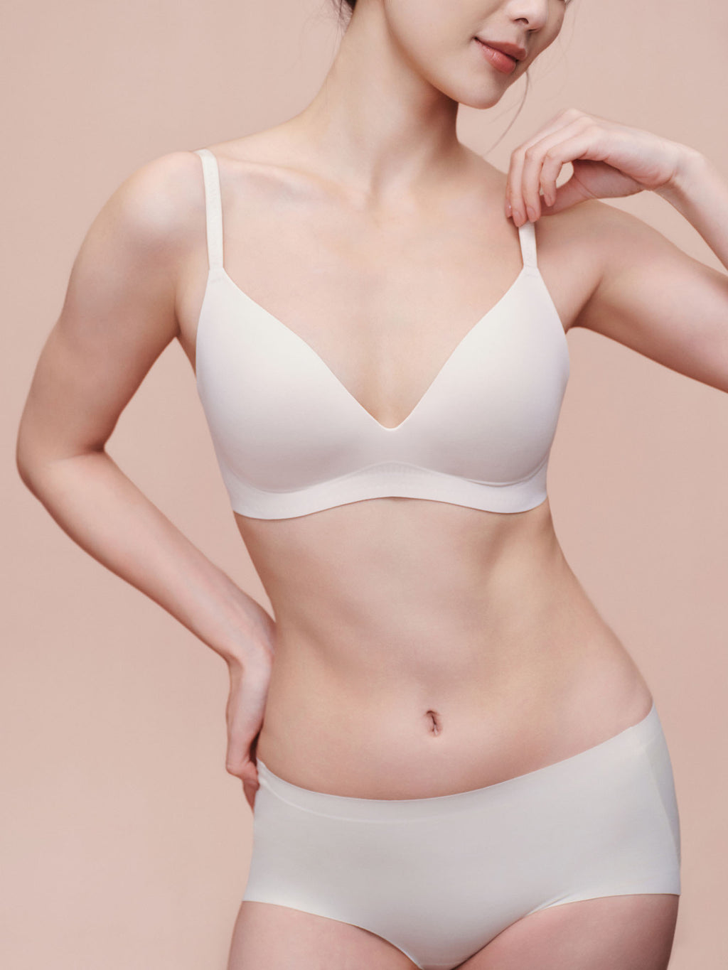 Model wearing white bra and brief set.