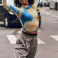 Dancer wearing blue and gold long sleeve top and gray pants